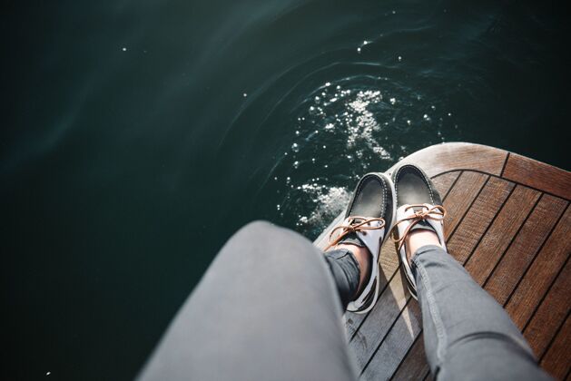 船白天在海上航行的船上的人的脚旅行谎言冒险