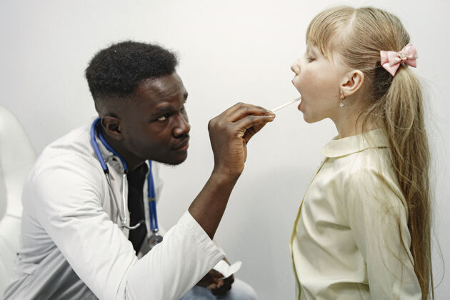 口腔穿白色制服的医生戴听诊器的男人留长发的女孩儿童检查酸痛