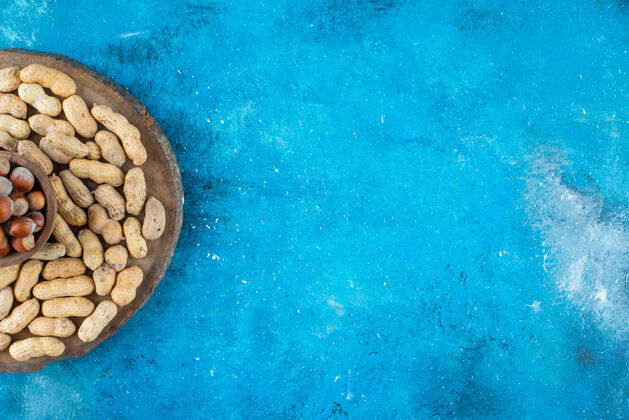 自然把榛子放在碗里 在蓝色的表面放上花生风味蛋白质可口