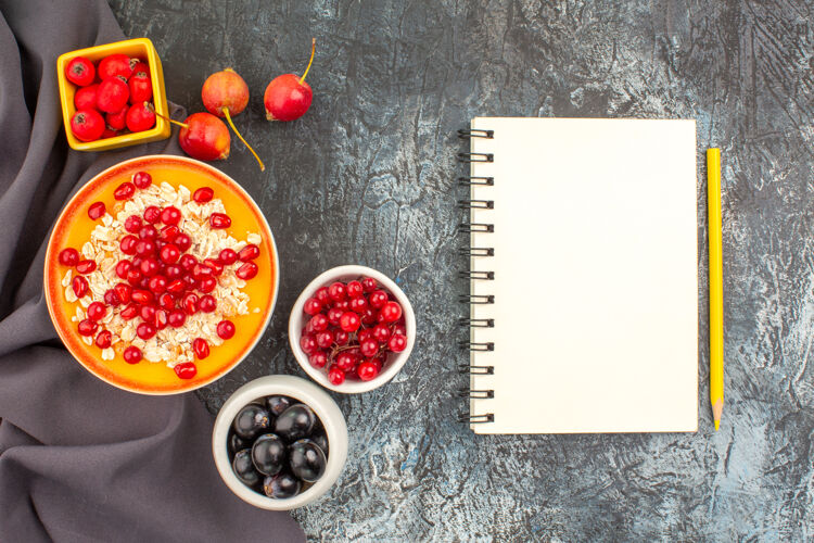 假日顶部特写查看浆果燕麦与石榴彩色浆果在桌布笔记本上美味饮食桌布