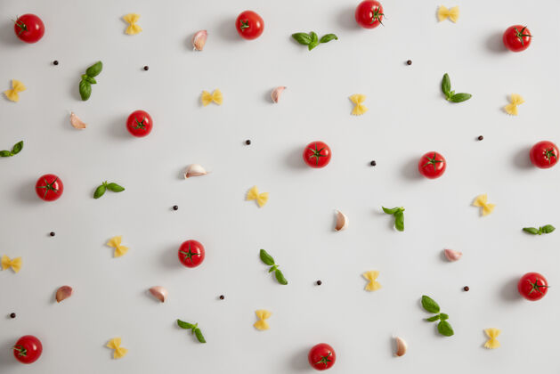 小麦生的法法勒蝴蝶结形状的意大利面 红西红柿 罗勒和香料 用于准备意大利食物选择性的重点作为碳水化合物来源的通心粉传统菜肴新鲜的未煮熟的原料面食新鲜粉制的