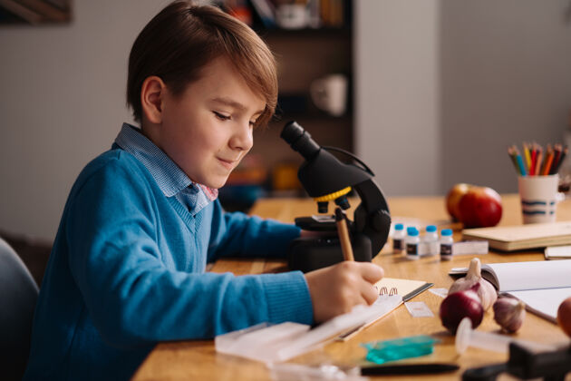 学习一年级男生在家用显微镜学习家庭学校远程木头