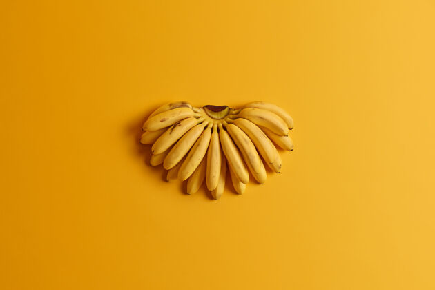 配料一束小成熟的婴儿香蕉含有健康的基本营养素隔离在黄色背景上夏季水果的概念平面 顶视图天然维生素来源饮食和健康食品美味农产品饮食