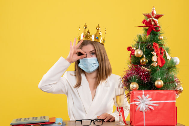 成人正面图：戴着无菌面罩戴着皇冠的女医生脸圣诞节病毒