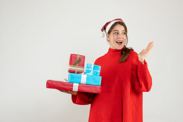 圣诞节前视图兴高采烈的女孩与圣诞老人帽子举行她的圣诞礼物年礼物空间