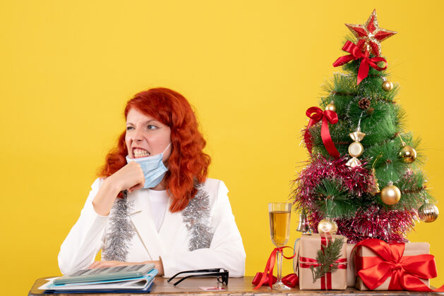 消毒前视图女医生围着圣诞树 戴着消毒口罩坐着导演颜色圣诞节