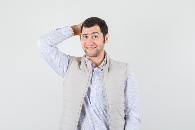 男性身穿米色夹克的年轻人手挽着后脑勺 看上去很乐观 正面看去手头肖像