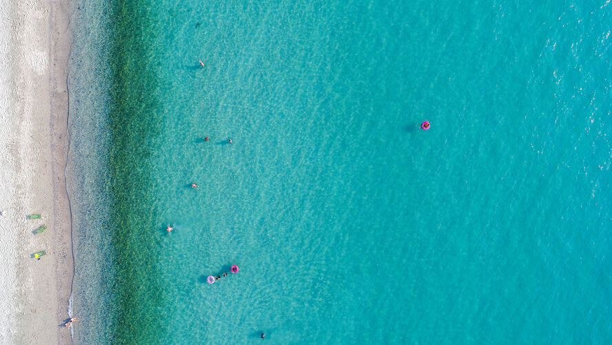 海洋鸟瞰沙滩与游客游泳人群热带雨伞