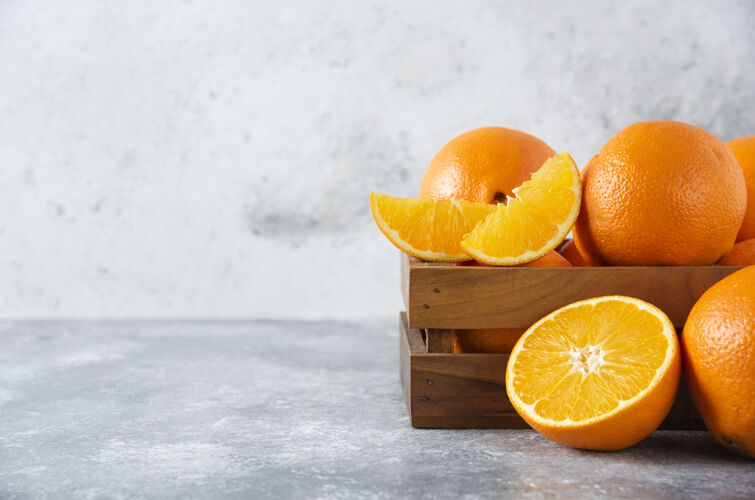 成熟石桌上放着一个木制的旧盒子 里面装满了多汁的橙子味道柑橘天然