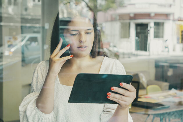 电脑严肃的女商人在手机上交谈 使用平板电脑 看着屏幕女人桌子企业家