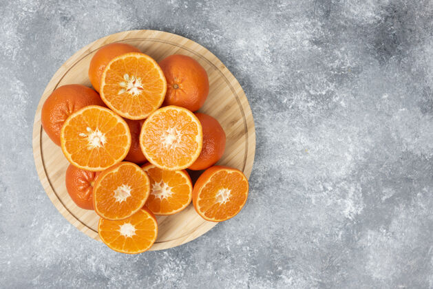 食品把新鲜多汁的橙子切片放在木盘里切片有机橙子片