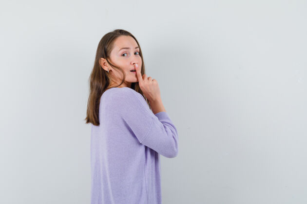 化妆年轻的女性一边回首 一边表现出沉默寡言的姿态 一边穿着淡紫色的上衣 看上去很平静衬衫展示优雅