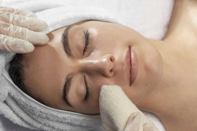 眉毛治疗在美容院放松的年轻女人美容治疗客户