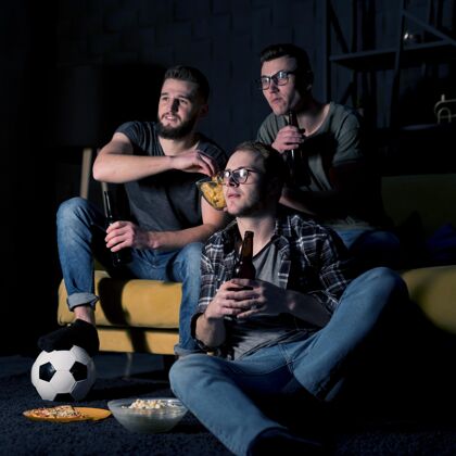 体育男性朋友一起看电视体育节目 一边吃零食和啤酒足球伙伴一起