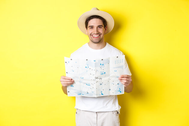 自信旅行 度假 旅游理念微笑的年轻人 拿着路线图 微笑着 站在黄色的背景上男性假日工作室