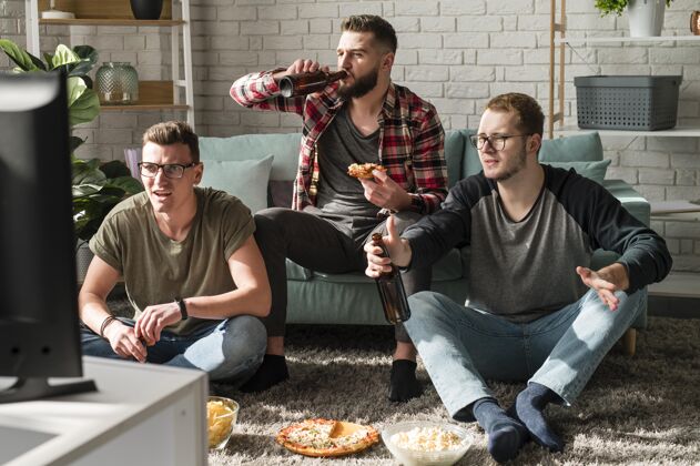体育男性朋友吃比萨饼和看电视上的啤酒运动的正面图伙伴电视最好的伙伴