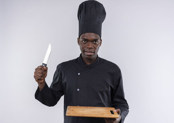 板年轻自信的美国黑人厨师身着厨师制服 手持白色的砧板和刀 留有复印空间信心刀烹饪