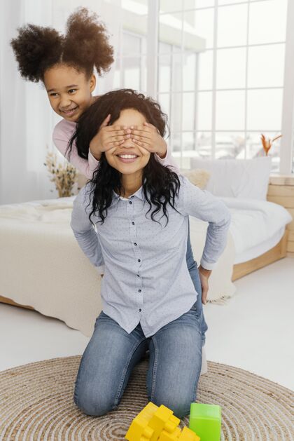 垂直笑脸妈妈和女儿在家玩母亲室内女人