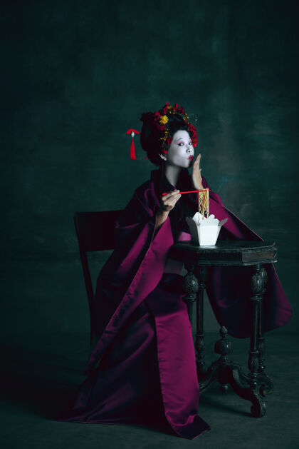 比较梦幻年轻的日本女人像艺妓一样孤立在深绿色的墙上复古的风格 比较时代的概念漂亮的女模特喜欢鲜明的历史人物 老式的中世纪艺妓巴洛克