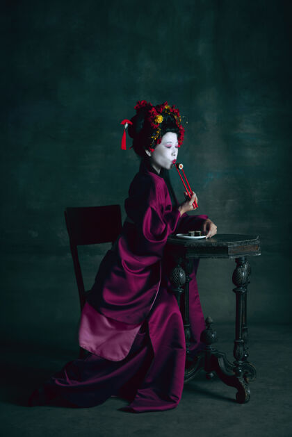 日本人梦幻年轻的日本女人像艺妓一样孤立在深绿色的墙上复古的风格 比较时代的概念漂亮的女模特喜欢鲜明的历史人物 老式的文艺复兴情感艺妓