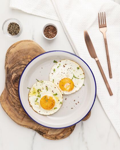 自制平铺的早餐煎蛋在盘子里和餐具垂直早餐美味
