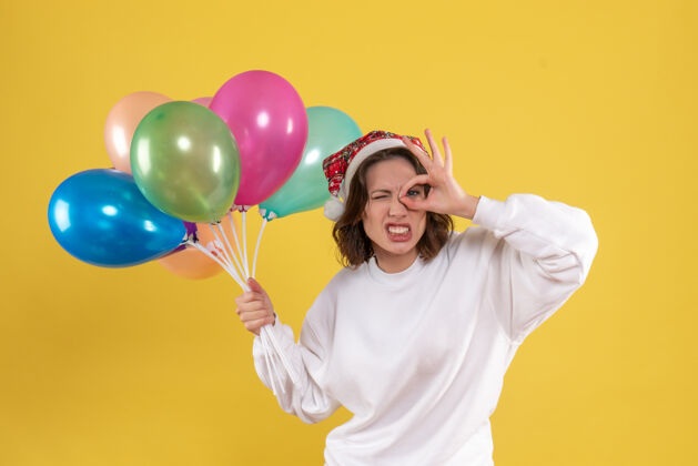 女人正面图：手持黄色气球的年轻女子正面情感气球