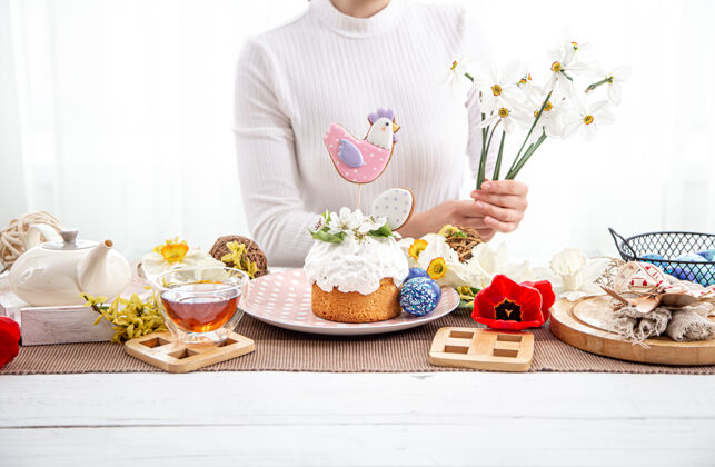 茶用复活节蛋糕装饰作品的过程复活节假期装饰的概念桌子设置女人