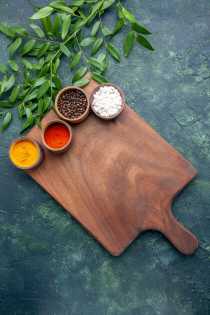 尖锐顶视图不同调味品搭配棕色木质书桌上的深蓝色桌子颜色木质锐利树绿色厨房勺子颜色美食