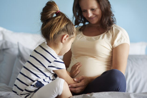 微笑孕妇和她的小女儿人类腹部预期亲子关系