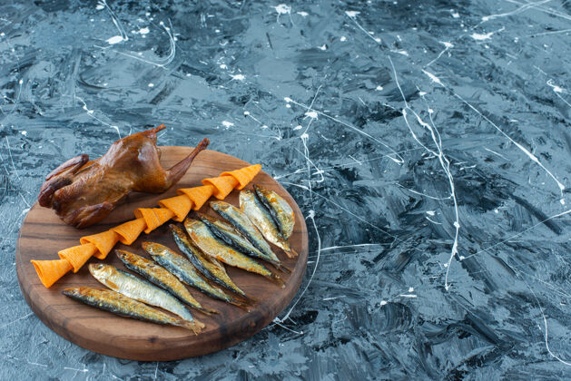 风味薯条 烤鸡和鱼在一块木板上 大理石背景上美味烘焙板