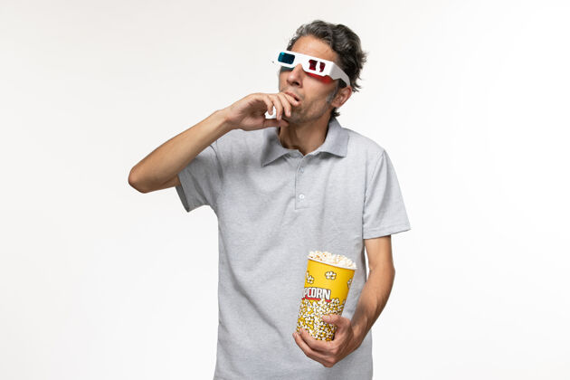 包装正面图年轻男性手持爆米花包 戴着d墨镜 白色表面太阳镜眼镜爆米花