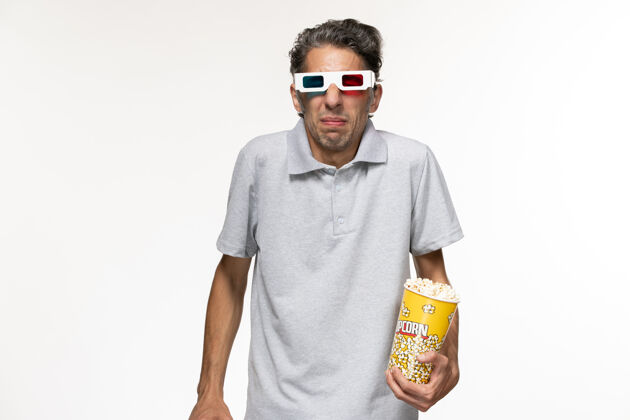 护目镜正面图年轻男性戴着d型太阳镜吃爆米花在白色表面看电影前面远程看