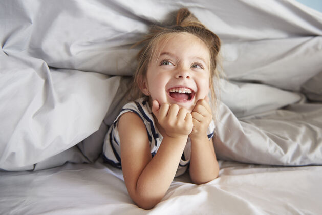 欢笑在床上玩得开心的女孩童年享受孩子