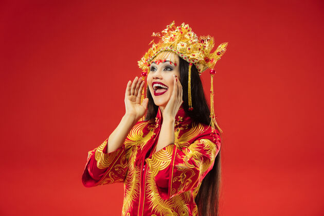 肖像中国传统的优雅女子在红墙工作室时尚中国优雅