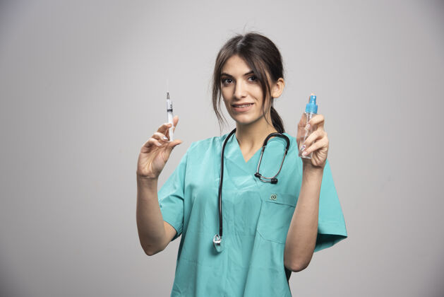 肖像女医生拿着喷雾瓶和注射器个人检查医疗