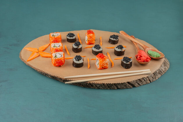 食物把寿司和几勺腌姜和芥末放在木板上搅拌鱼寿司腌姜