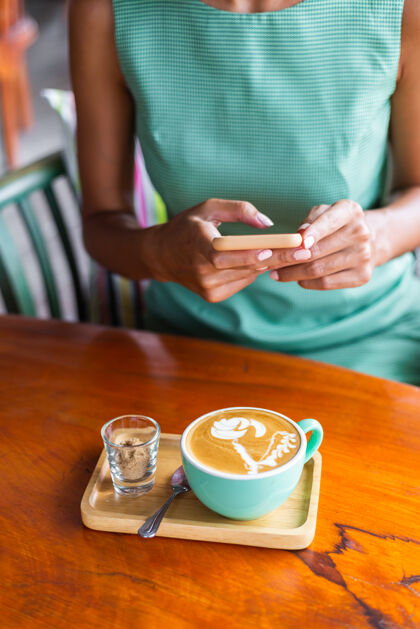 一可爱 优雅 平静 快乐的女士 穿着绿色夏装 坐在咖啡馆里喝咖啡 享受早晨放松女士年轻