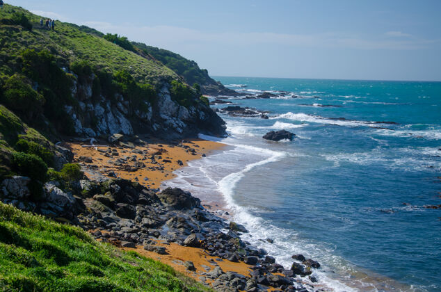悬崖波涛汹涌的大海冲击着新西兰悬崖环绕的岩石海滩沙滩Swoosh击中