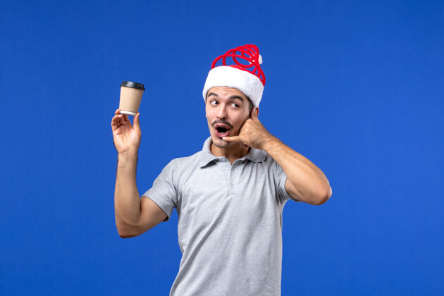 杯子正面图青墙男青年手持塑料咖啡杯过年肖像表演圣诞节