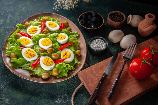 橄榄上图鸡蛋沙拉由橄榄和深蓝色背景的绿色沙拉组成菜肴盘子膳食
