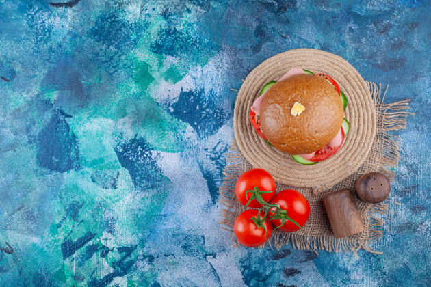 食品美味的自制汉堡包 蓝色表面有新鲜西红柿小吃顶视图面包