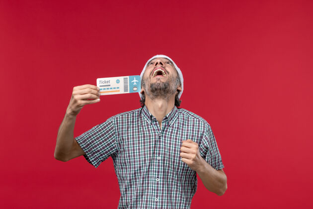 男人正面图：年轻男子手持红色背景的车票圣诞节肖像票