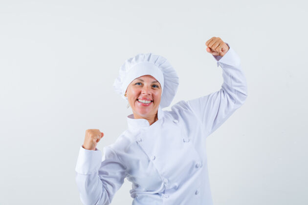 卷发身着白色制服的女厨师展示获奖者的姿态 看上去很幸运时尚优雅时尚