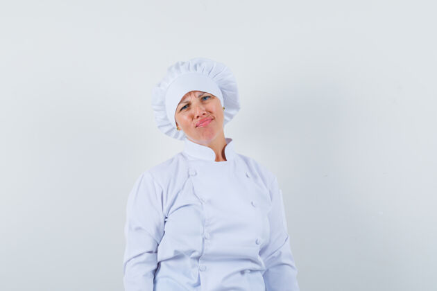 年轻一个穿着白色制服的女厨师看着前面 看上去很失望脸女性时尚