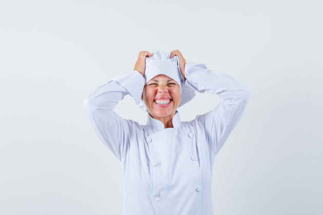 年轻一位身穿白色制服的女厨师手把手举在头上 看上去很高兴脸优雅现代