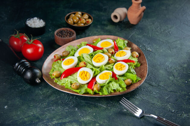 前面正面图美味的鸡蛋沙拉由绿色沙拉和橄榄色背景组成橄榄沙拉晚餐