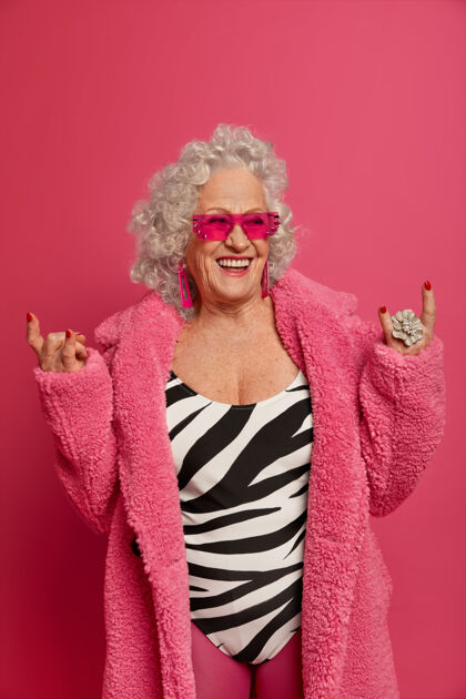 戒指快乐的老皱纹女人做摇滚的象征 穿着最新的时尚潮流符号朋克祖母