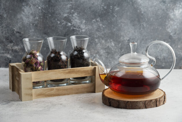 茶杯在木板上放着茶的玻璃茶壶提神饮料茶壶
