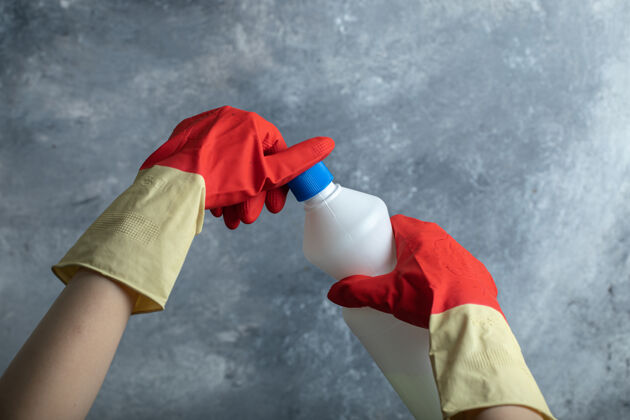 液体手戴红色手套打开漂白剂的容器家用卫生液体