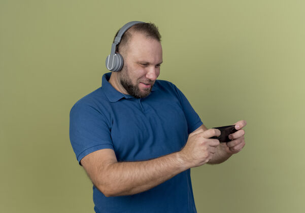 耳机娱乐成人斯拉夫男子戴耳机使用手机橄榄色电话佩戴